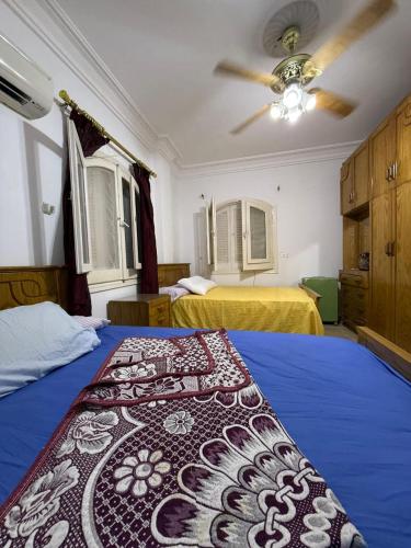 a bedroom with two beds and a ceiling fan at Spacious Villa with Pool and Sea View in Dawwār ‘Abd Allāh