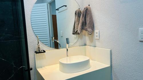 a bathroom with a white sink and a mirror at Pousada Ventos in Chapada dos Guimarães