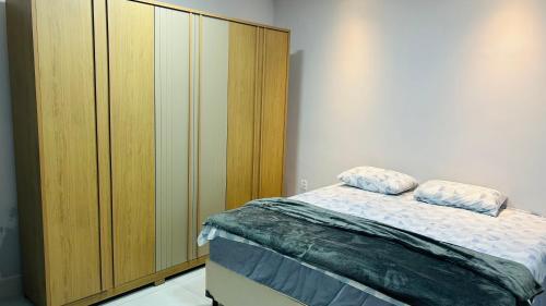 a bedroom with a bed and a wooden cabinet at Pousada Ventos in Chapada dos Guimarães