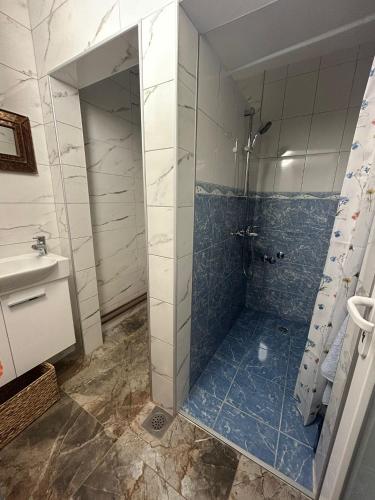 a bathroom with a shower with blue tile at Stara Ruža in Gračanica
