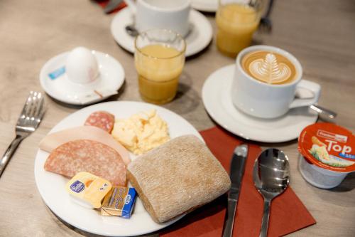 een tafel met een bord eten en een kopje koffie bij Hotel 22 in Dessau