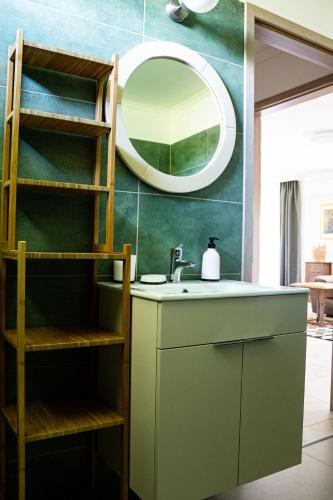 a bathroom with a sink and a mirror at Rizling Vendégház in Balatonrendes