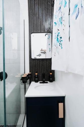 a bathroom with a sink and a mirror on a counter at Aintree Bungalow in Portmore
