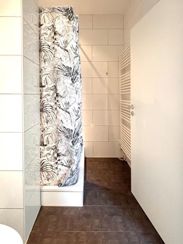 a walk in shower with a shower curtain in a bathroom at COZEE - The Oasis in Kaiserslautern