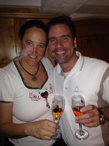 a man and a woman holding glasses of wine at Haus Odo in Lech am Arlberg