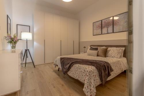 ein Schlafzimmer mit einem Bett und einem Tisch mit einem Stativ in der Unterkunft Loft Altobelli in Rieti