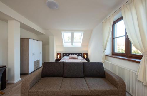 a living room with a couch and a bed at Hotel Tulipan in Tatranská Lomnica