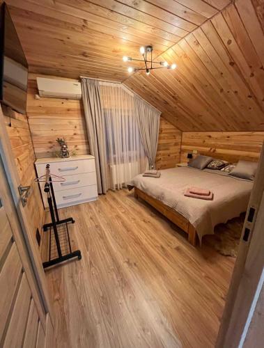 a bedroom with a bed in a wooden cabin at mountain house in Skhidnitsa