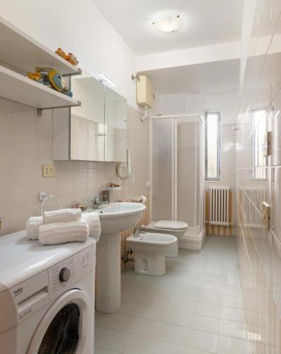 a white bathroom with a washing machine in it at Residence Stella Marina in Cupra Marittima