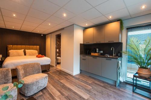 a hotel room with a bed and a kitchen and a kitchenstration at Tiny Boat House #6 in Garnwerd