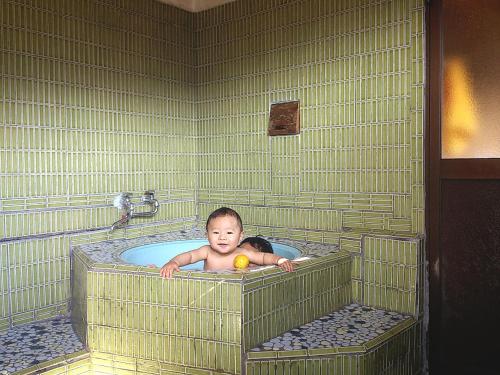a baby in a tub with an orange in it at Oyamanoyado Michitsuji in Otoyocho
