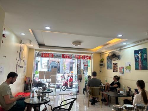 a group of people sitting at tables in a restaurant at Tnon Samui Hostel in Chaweng