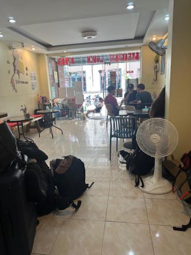 a restaurant with a table and people sitting at tables at Tnon Samui Hostel in Chaweng