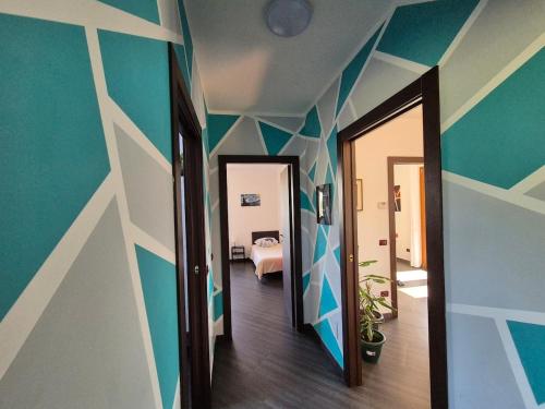 a hallway with blue and white striped walls and a bedroom at Casa Scova, entire apartment in Garlasco