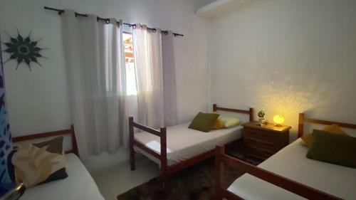 a bedroom with two beds and a window at Morada Amor & Cura Xamanismo in Mongaguá