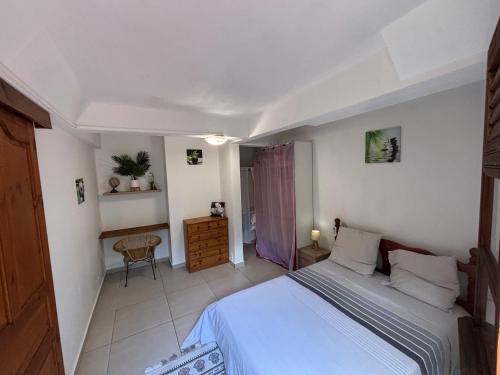 a bedroom with a bed and a desk in it at Villa Corail Les Abymes in Les Abymes
