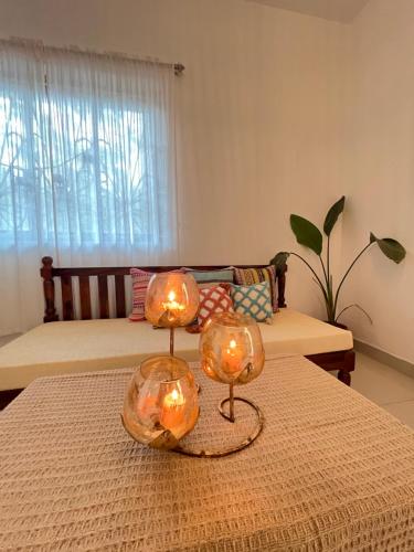 twee lichten op een tafel in een woonkamer bij White House Stay in Patnem