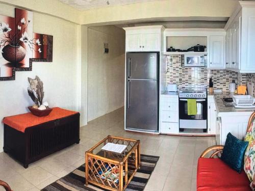 a kitchen with a stainless steel refrigerator and white cabinets at Ocean Grace - Canouan Island in Canouan