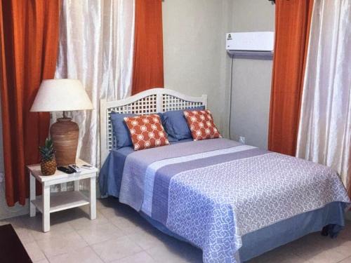a bedroom with a bed and a table with a lamp at Ocean Grace - Canouan Island in Canouan