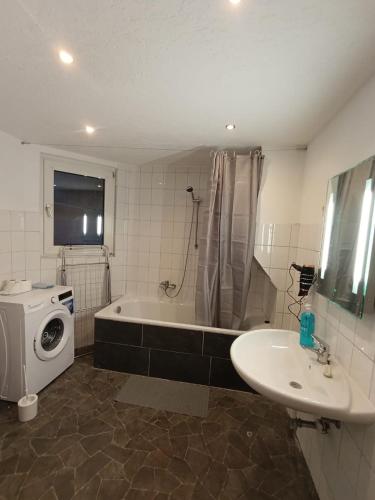 a bathroom with a tub and a sink and a washing machine at Praktische Monteurwohnung 2 Marl in Marl