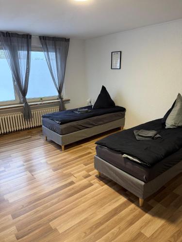 two beds in a room with wooden floors at Praktische Monteurwohnung 2 Marl in Marl