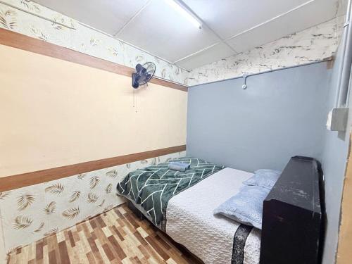 una piccola camera con letto e ventilatore di Budget Homestay Jelai a Gemas