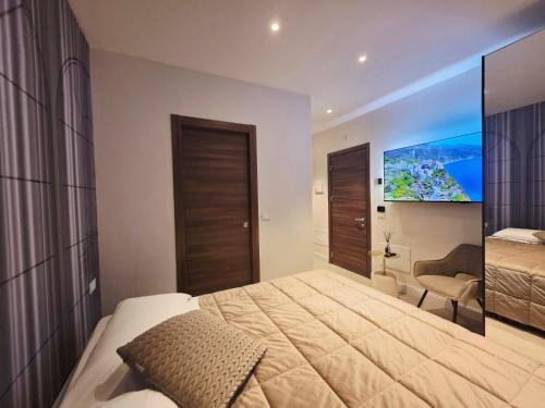 een slaapkamer met een groot bed en een flatscreen-tv bij Mirarti Boutique Hotel - Witamy in Rapallo