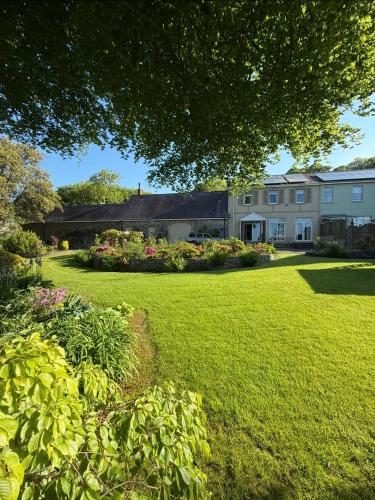 a large yard with a house and flowers at Gower view in Burry Port
