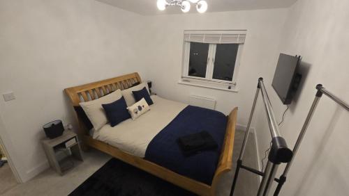 a bedroom with a bed with blue and white pillows at 3,Lime Tree Ave in Haverfordwest