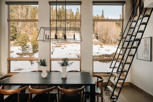 a dining room with a table and chairs in front of windows at The Lookout in Winter Park