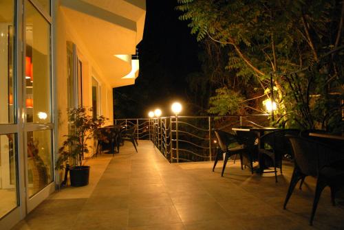 an outdoor patio with tables and chairs at night at Hotel Avis in Sandanski
