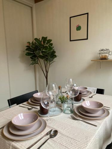 a table with plates and wine glasses on it at Oniris - Parenthèse urbaine in Mont-de-Marsan