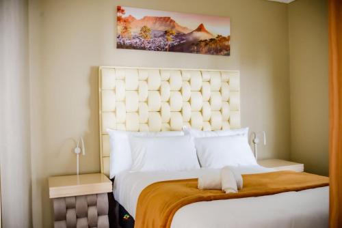 een slaapkamer met een groot wit bed met een groot hoofdeinde bij Makay's Guests house in Kimberley