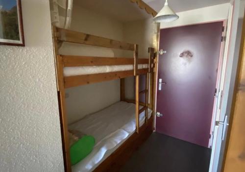una stanza con due letti a castello e una porta viola di Charmant Studio a Prémanon