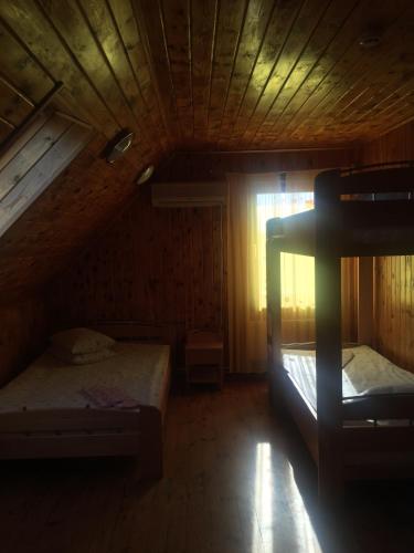 a bedroom with two beds in a wooden cabin at Guest house Citrons in Čornaja