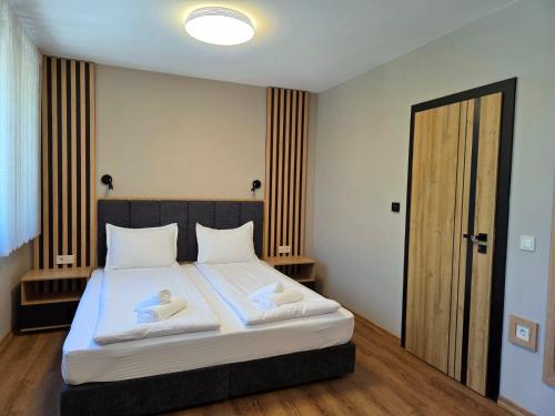 a bedroom with a bed with two towels on it at Хотел Ресторант Ваката in Teteven