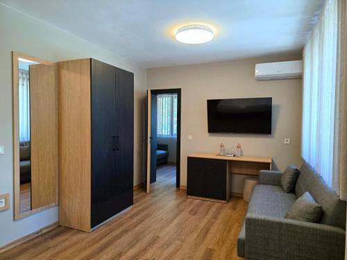 a living room with a couch and a flat screen tv at Хотел Ресторант Ваката in Teteven