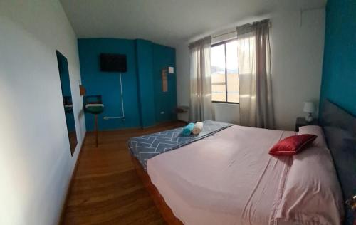 una camera da letto con un letto grande e una finestra di Cómodo y acogedor departamento familiar, cerca del casco histórico a Gualaceo