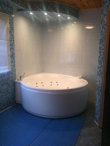 a white bath tub in a bathroom with a window at Guest house Citrons in Čornaja