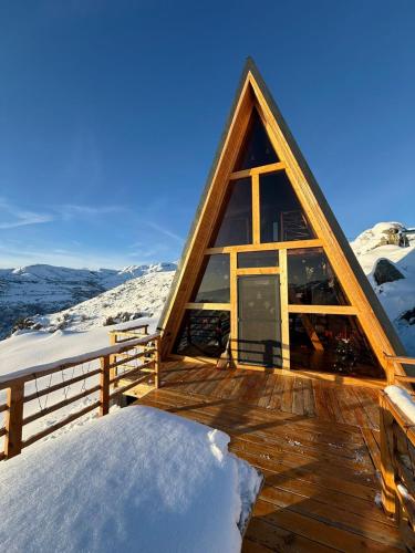 uma cabana com um deck de madeira na neve em SapsanLodge em Artabuynkʼ