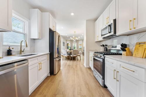 a kitchen with white cabinets and a dining room at New 10-min to Downtown in Oak Park