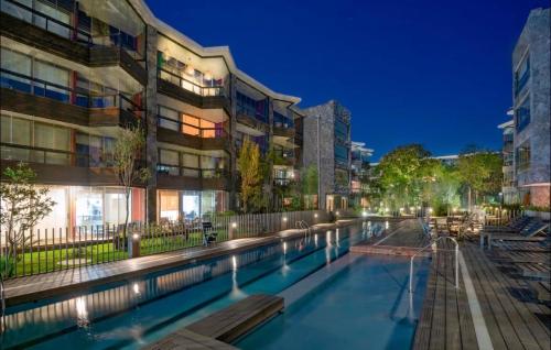 una piscina di fronte a un edificio di notte di Departamento Refugio Vista al Volcán Pucón a Pucón