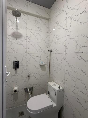 a bathroom with a white toilet in a room at فندق حمورابي Hammurabi Hotel in An Nāşirīyah