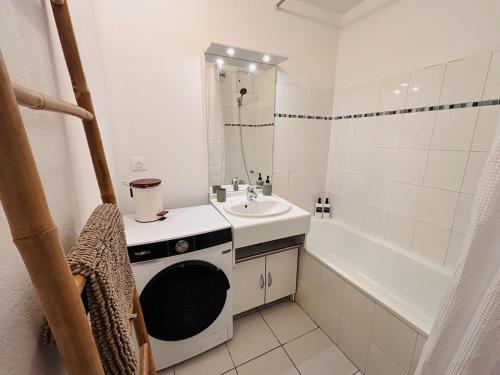 a small white bathroom with a sink and a tub at L'appartement du Château in Pfastatt