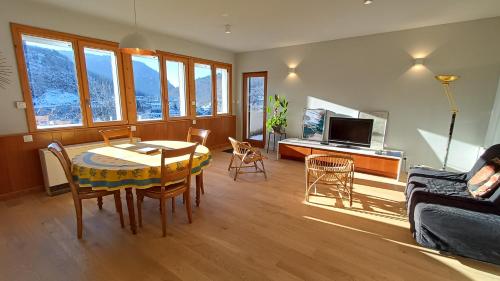 a living room with a table and chairs and a couch at Gite La Cueille in Saint-Claude
