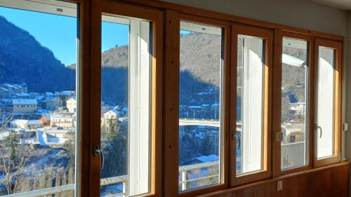 a group of windows with a view of a city at Gite La Cueille in Saint-Claude