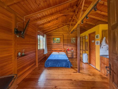 a bedroom with a bed in a wooden cabin at Refúgio do Vale in Urubici