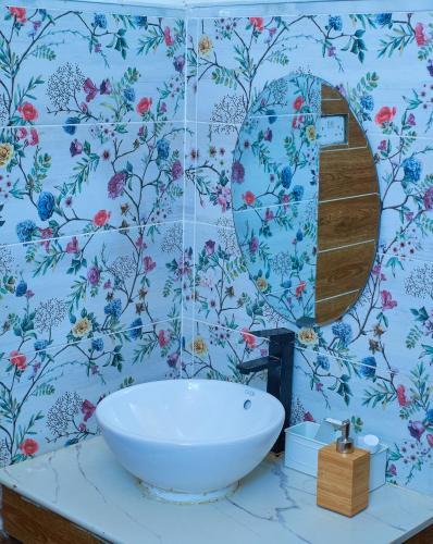 a bathroom with a white sink and a mirror at Tropical lodge in Kakamega