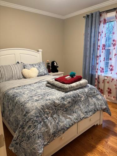 a bedroom with a bed with a gray and white comforter at 12Birchwood in Holbrook