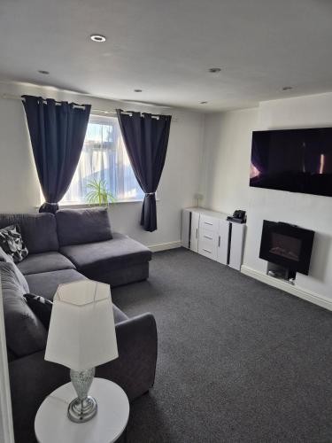 a living room with a couch and a flat screen tv at 5 min from airport, luxury 2 bed apartment in Luton